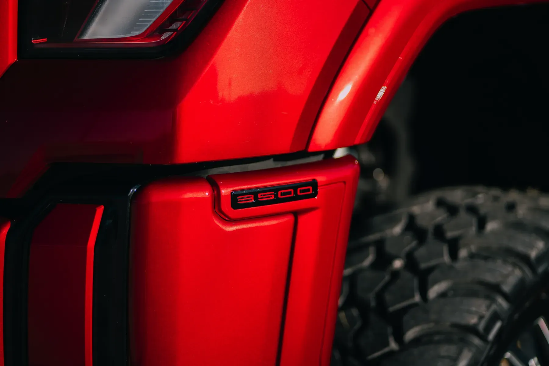 Close-up of the red fender and tire of a vehicle.