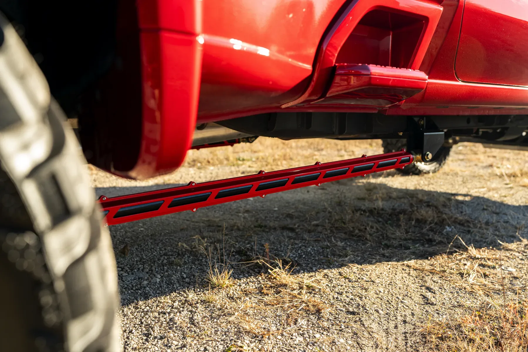 Close-up of the red suspension linkage on a lifted truck.