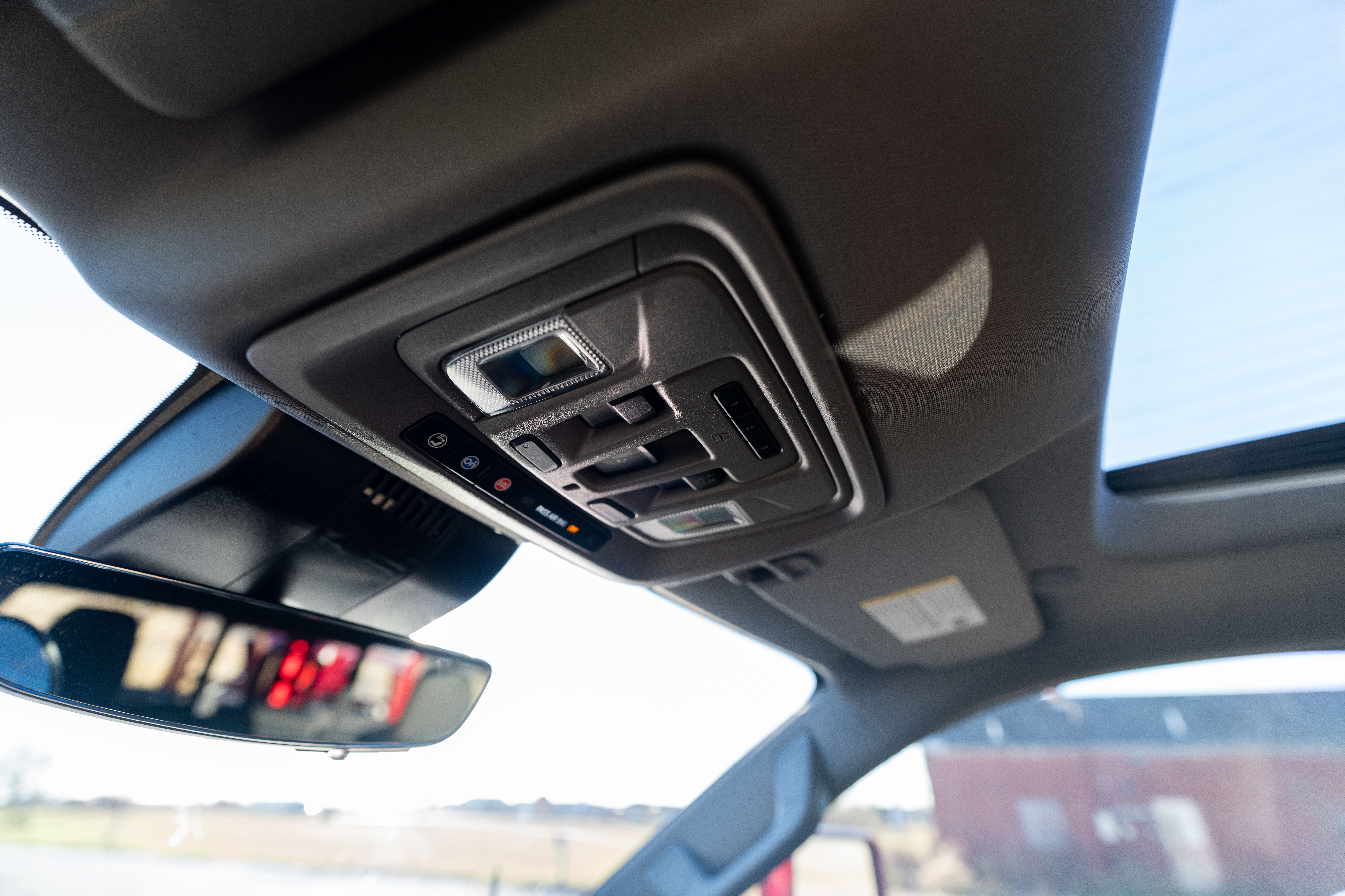 Overhead console with controls and a sunroof in a modern car interior.
